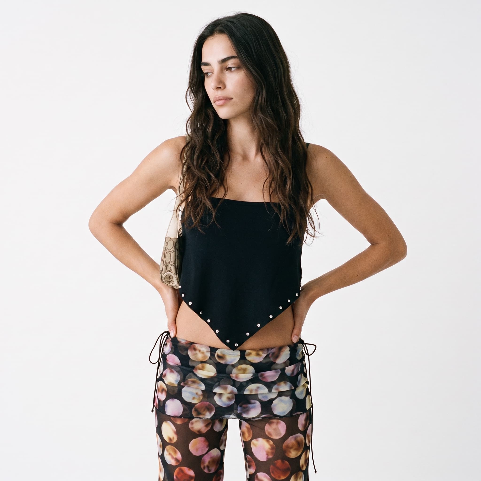 A trend-driven look: a black studded asymmetric top with sheer printed trousers.